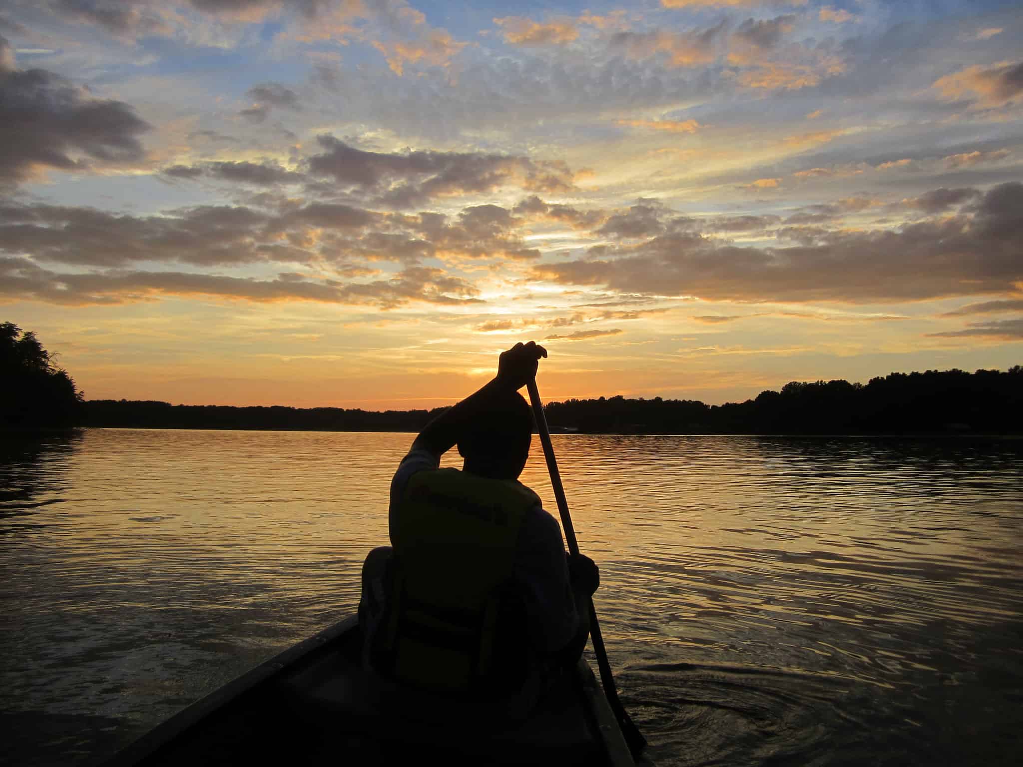 image of person canoeing at sunset