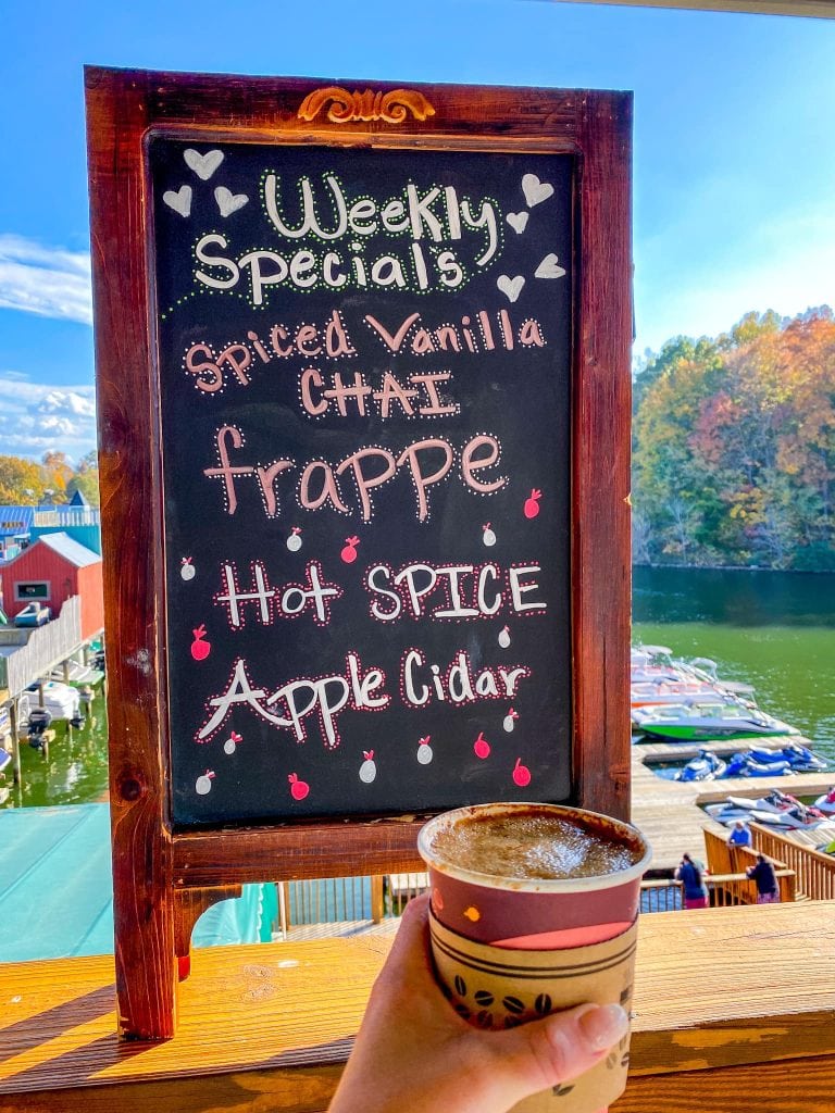 A hot spiced apple cider from Smith Mountain Lake Coffee House with fall foliage in background