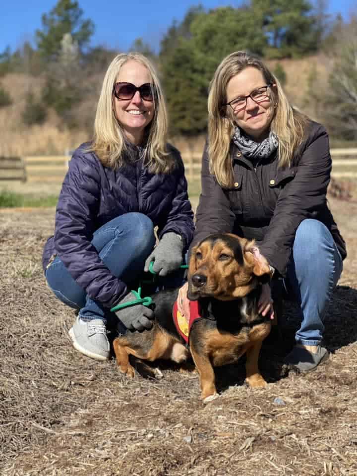 Two women pose with an adoptable dog during an event at SML Pavilion.