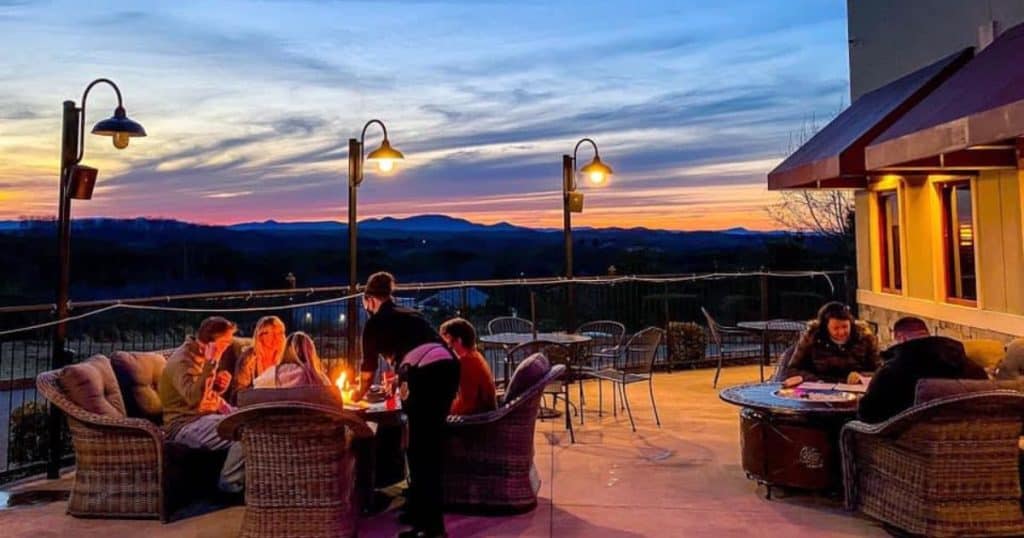 A sunset of oranges and purples over the mountains on the deck at The Copper Kettle restaurant at Smith Mountain Lake.