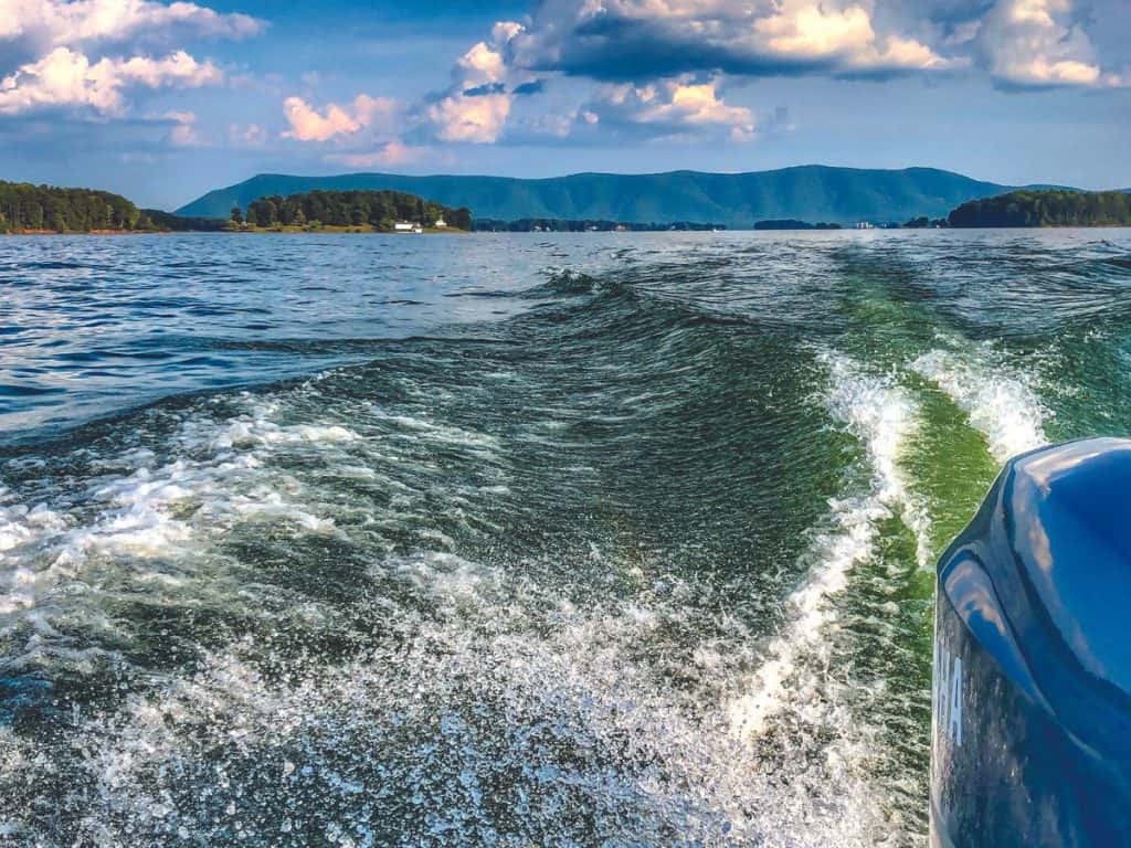 The wake of a boat with Smith Mountain in the background.