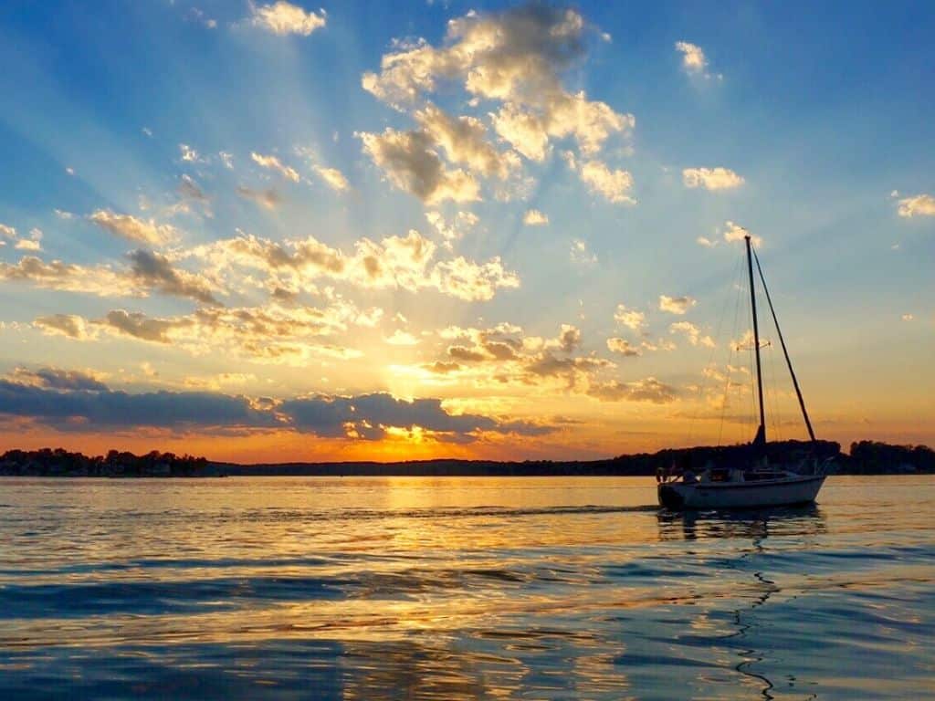A sailboat illuminated by an orange sunset on Smith Mountain Lake, VA