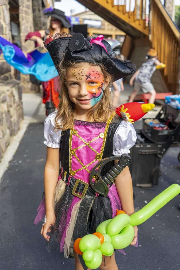 Small girl dressed as pirate with face painted.