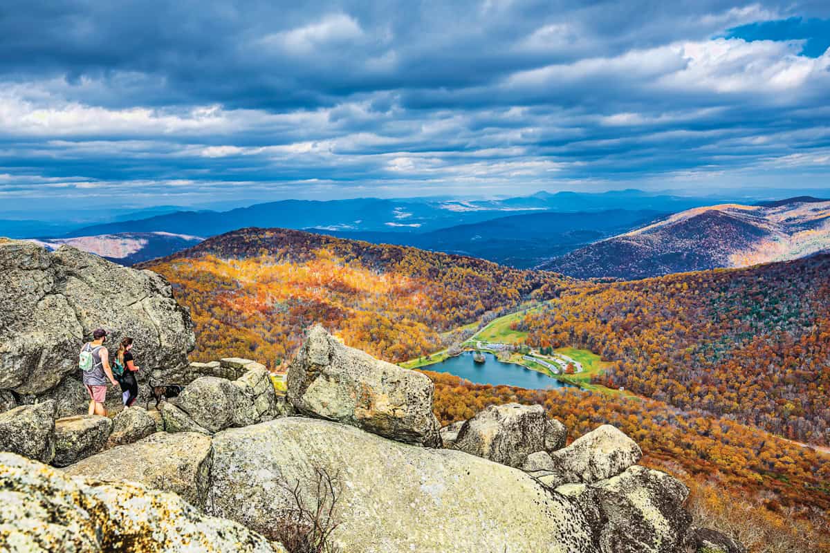 Two hikers summit Sharp Top Mountain in Bedford County in the autumn.