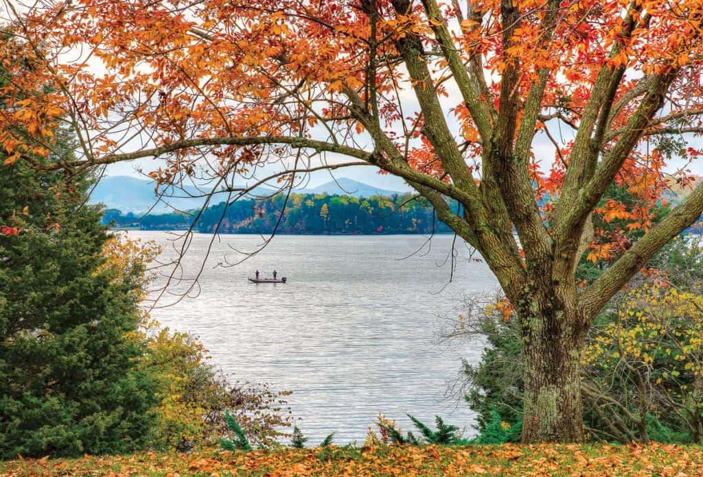 Orange and yellow fall foliage frame a pair of fishermen on Smith Mountain Lake, Va.