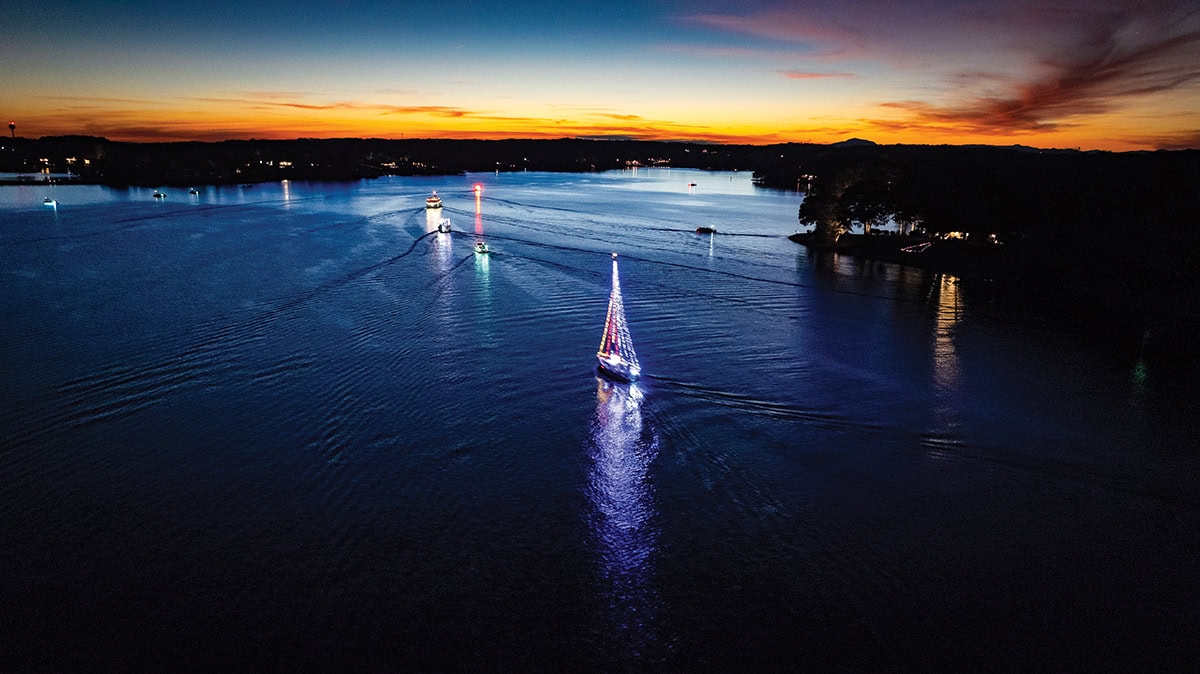Decorated boats illuminated at night during the SML Lighted Boat Parade.