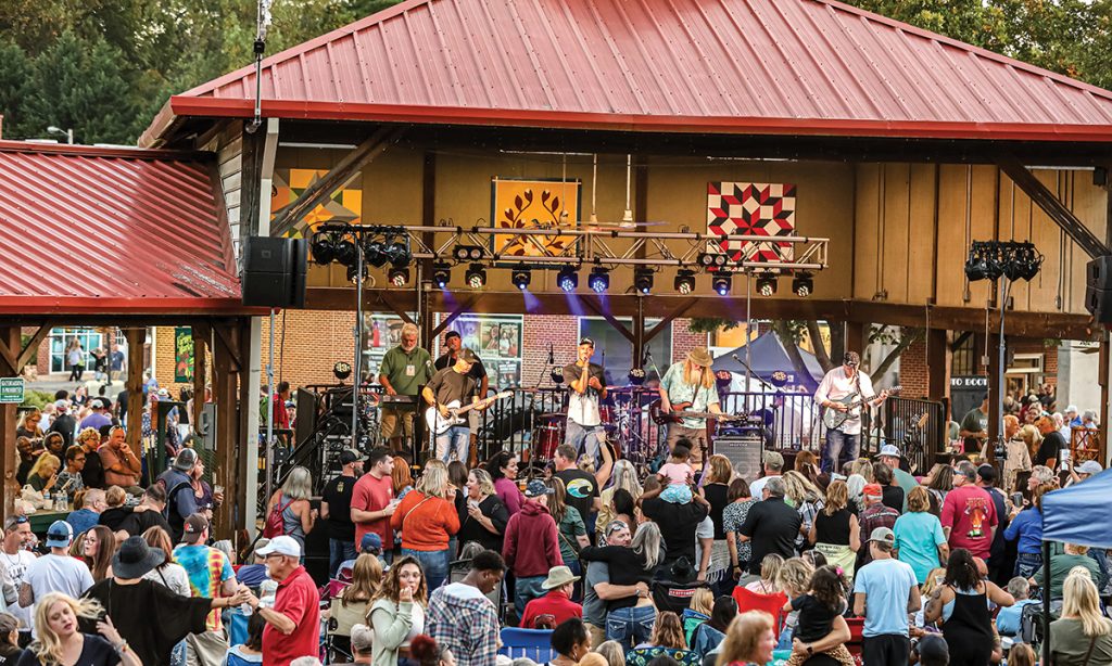 Downtown Rocky Mount Fest street scene with live band, vendor tents and families strolling.