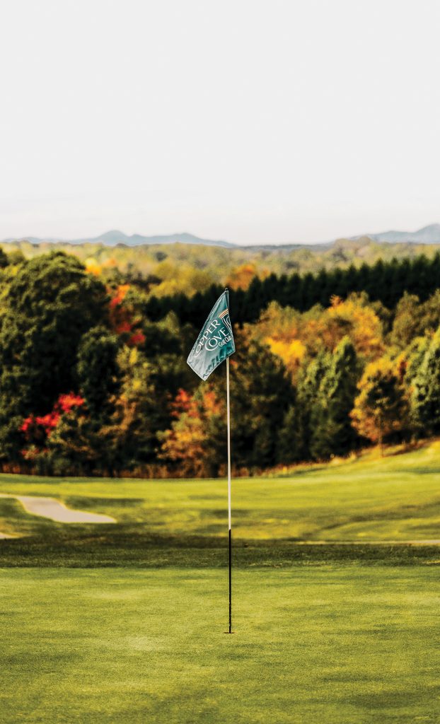 Golf flag at Copper Cove Golf Club with rolling green fairways and colorful fall foliage at Smith Mountain Lake, Virginia.