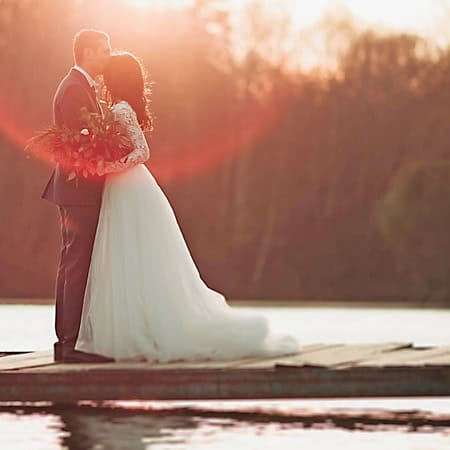 bride and groom posing for wedding photo on a dock at Smith Mountain Lake, Virginia