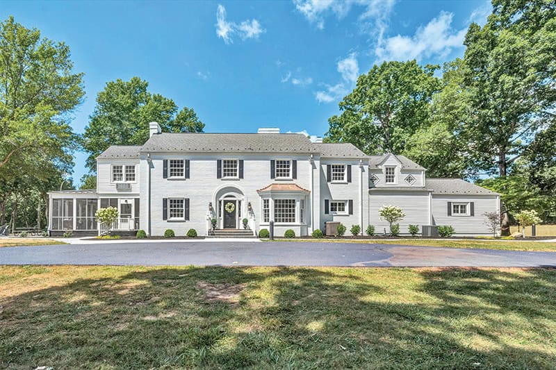 Exterior of Milan Manor House at Smith Mountain Lake. Historic home with two floors and large porch.