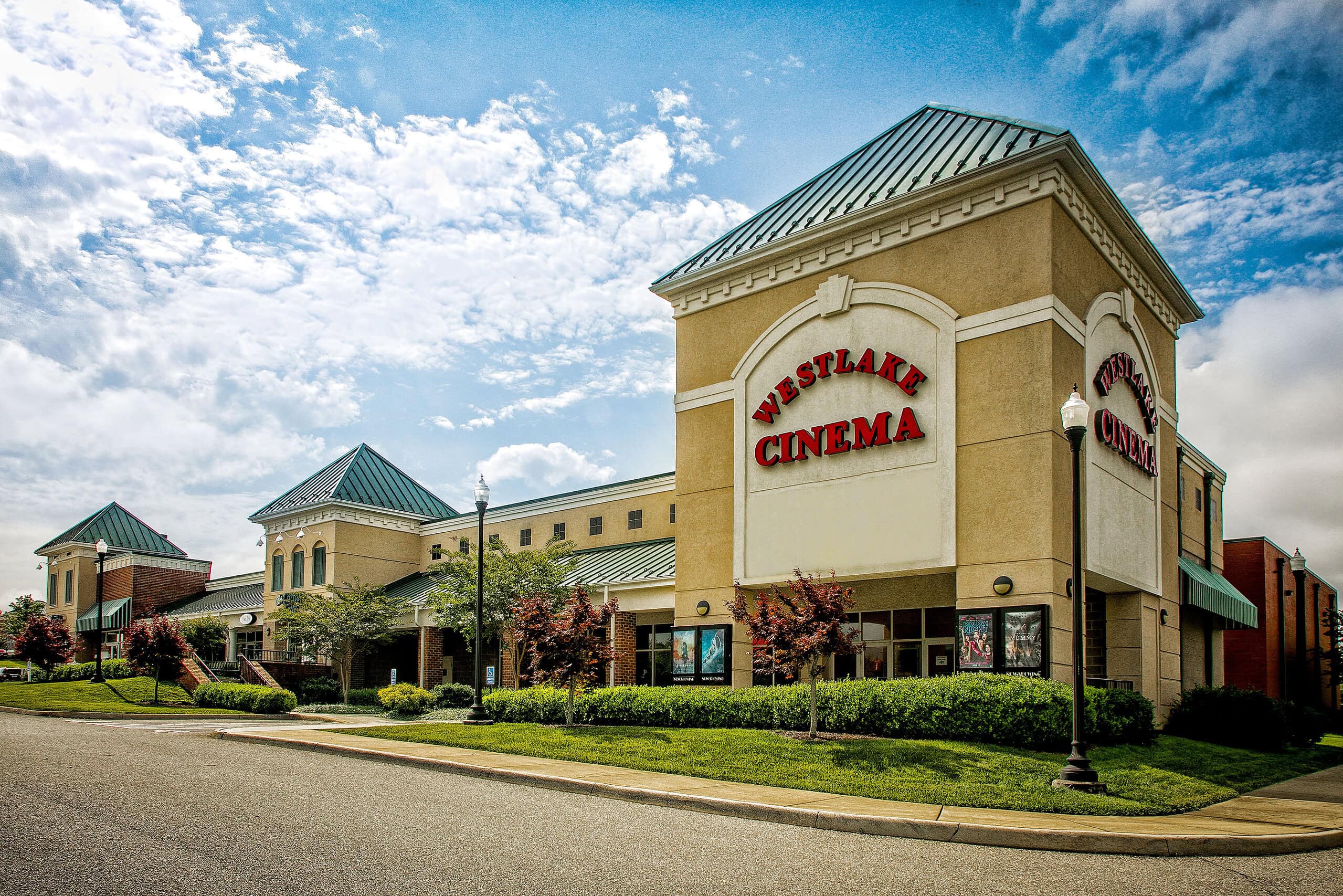 Exterior of movie theater Westlake Cinema with blue sky and clouds