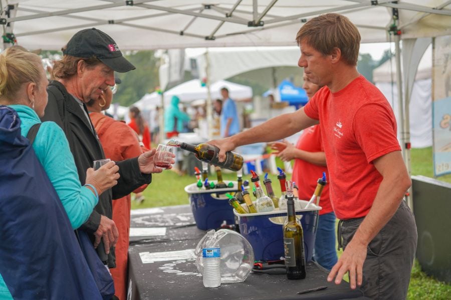 Winery owner pours a sample for SML Wine Festival attendee.