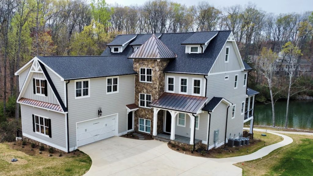 Three-story large vacation rental home with stone exterior and view of Smith Mountain Lake.