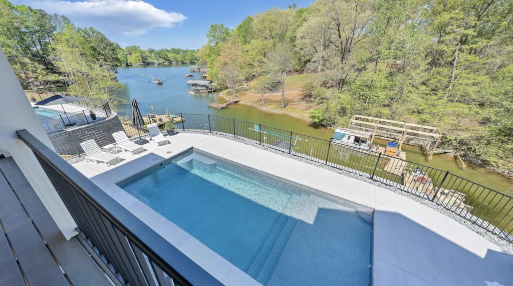 Shimmering pool overlooking quiet cove on Smith Mountain Lake at a large rental home ideal for multi-family getaways.