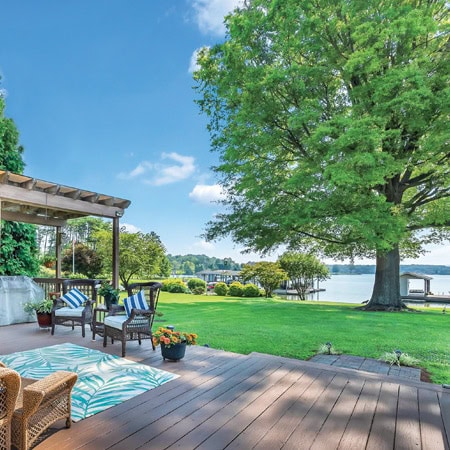 Relaxing outdoor deck with blue lake and trees in background at Smith Mountain Lake, Virginia.