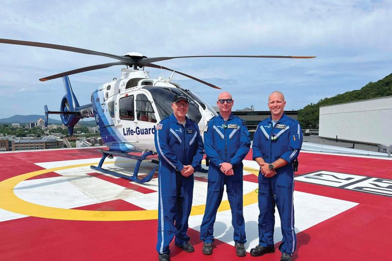Carilion Life-Guard air ambulance flight crew members in blue flight suits standing together at helipad