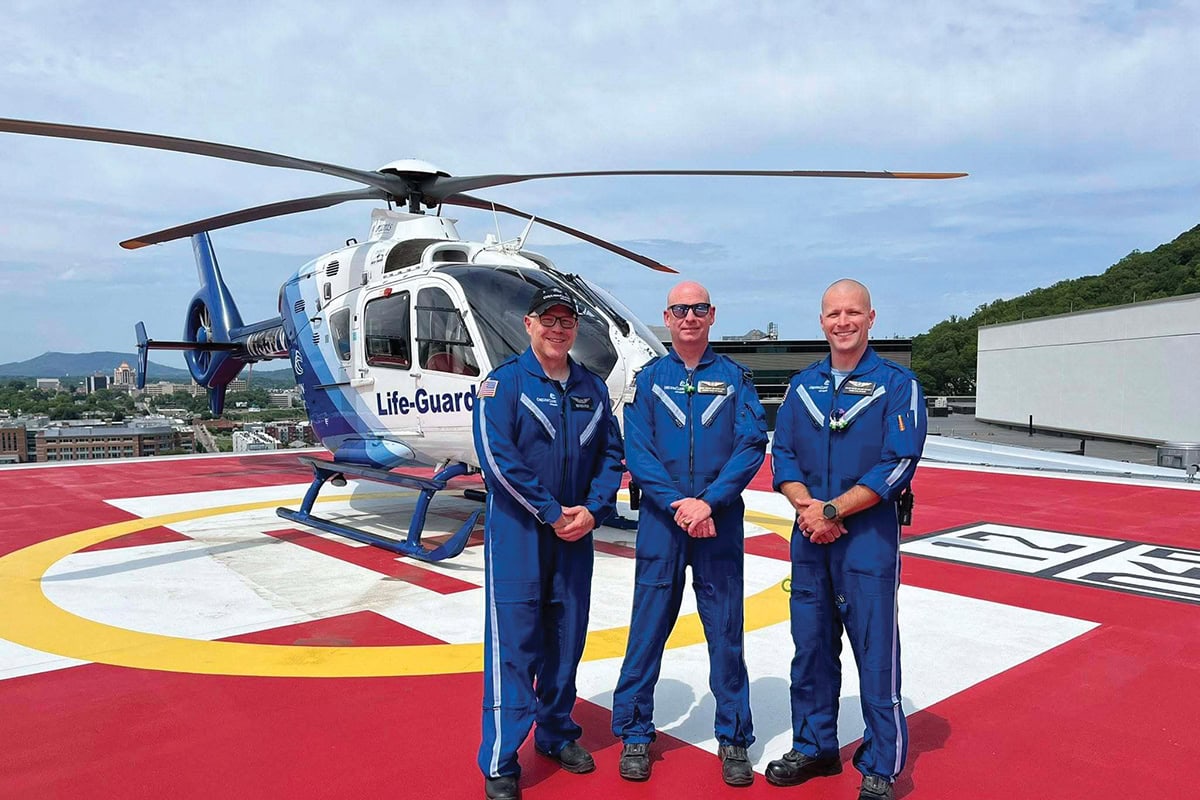 Carilion Life-Guard air ambulance flight crew members in blue flight suits standing together at helipad