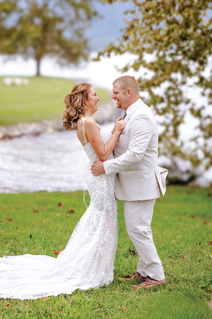 Bride and Groom standing on lawn at Parkway Marina with Smith Mountain Lake behind them