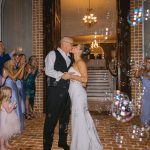A bride and groom walk out for a bubble send off at Smith Mountain Manor wedding venue, photographed by Amative Creative
