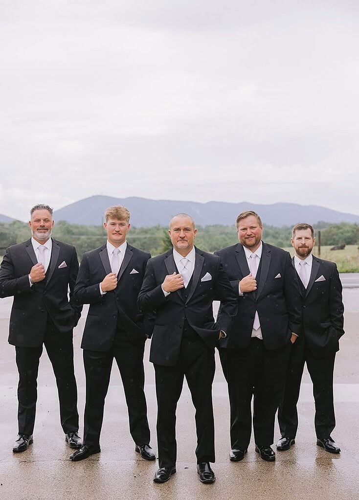 A groom and his groomsmen stand in front of Smith Mountain at Smith Mountain Manor wedding venue, photographed by Amative Creative