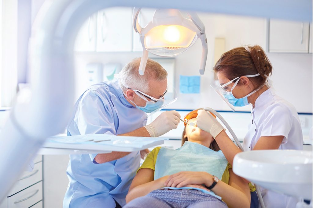 Dentist examining patient in modern dental office with professional equipment and bright lighting