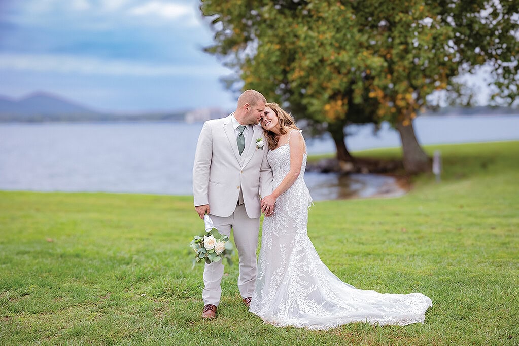 Bride and Groom standing on lawn at Parkway Marina with Smith Mountain Lake behind them