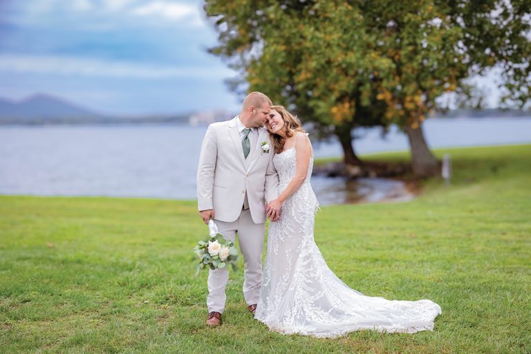Bride and Groom standing on lawn at Parkway Marina with Smith Mountain Lake behind them