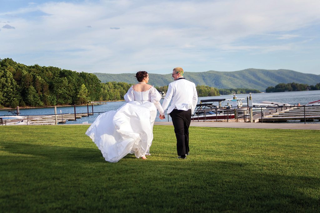 A bride and groom walk across the grounds at Mariners Landing Resort at Smith Mountain Lake, photo courtesy of Mariners Landing.