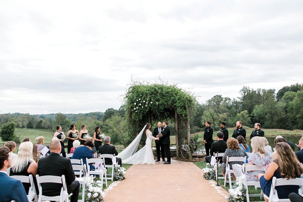 A bride and groom exchange vows at the altar during their wedding at The Pavilion at Black Water Junction, Smith Mountain Lake, photographed by Lighthaven Photography.