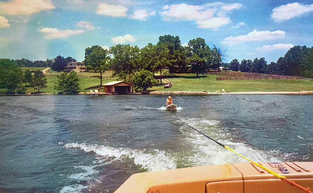 Person enjoying water activities at Smith Mountain Lake, Virginia, with a boat and a dock in the background.