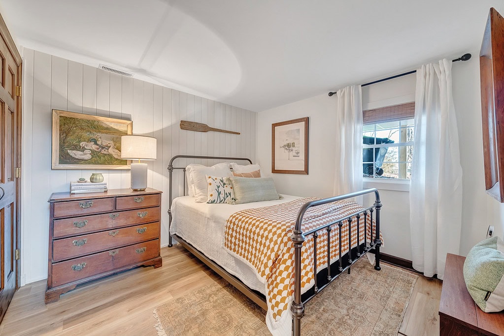 Cozy guest room with pine floors and eclectic furniture.