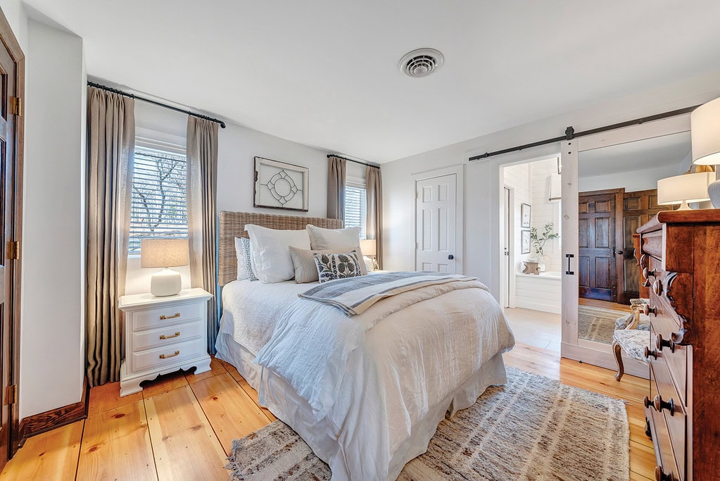 Master bedroom with pine floors in Moneta cottage renovation.