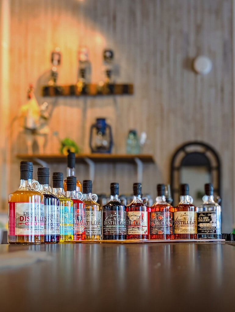 Colorful bottles of spirits lined up on the bar of a Smith Mountain Lake distillery at Bridgewater Plaza.