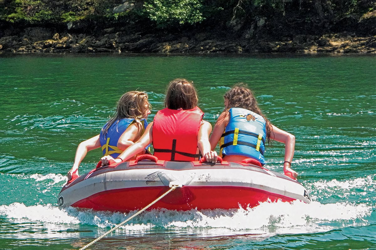Three kids on an inflatable at Smith Mountain Lake, Virginia.