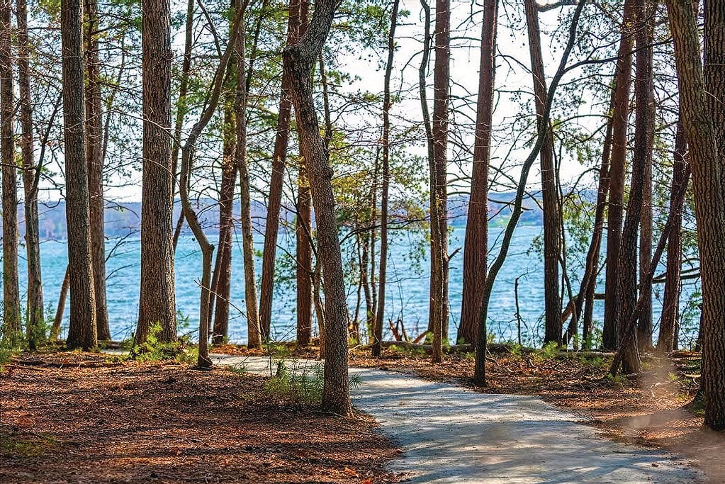 A trail leads around the peninsula at SML Community Park with the lake and Smith Mountain in the background.