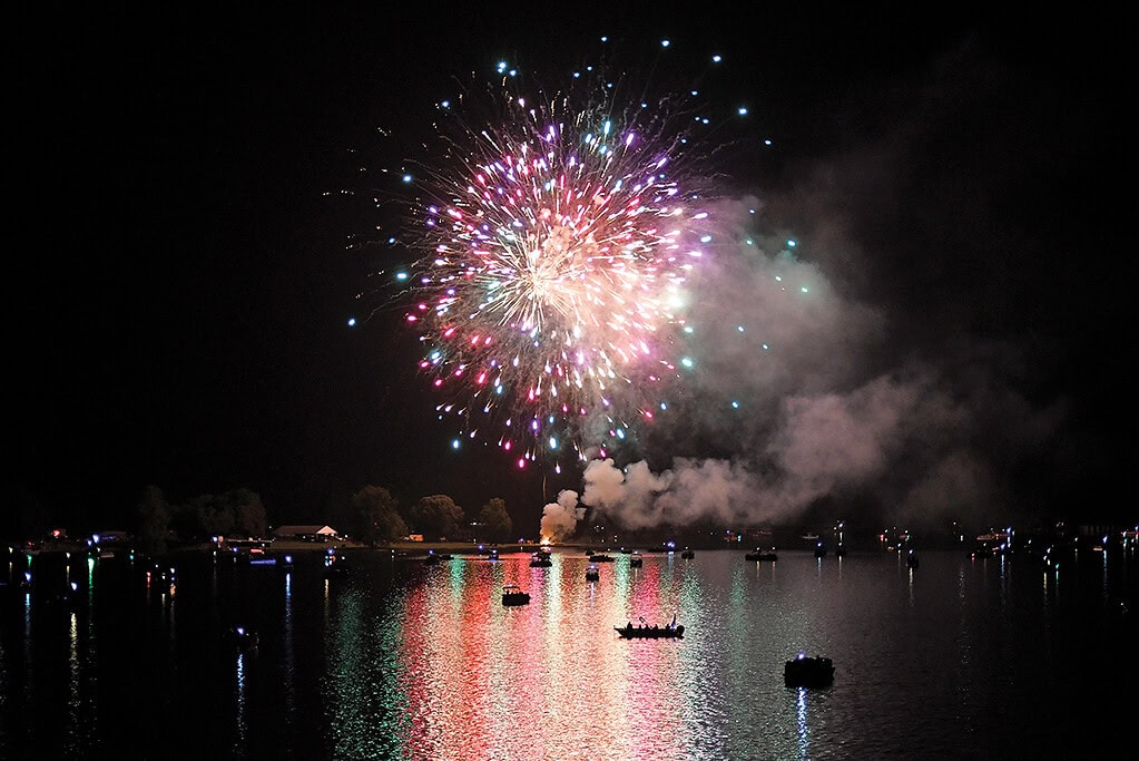 Colorful fireworks are reflected in the water at Smith Mountain Lake, Virginia.