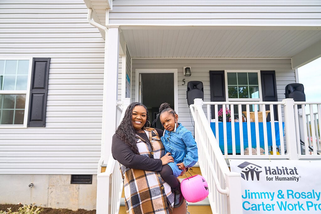 A Habitat partner family outside their completed home
