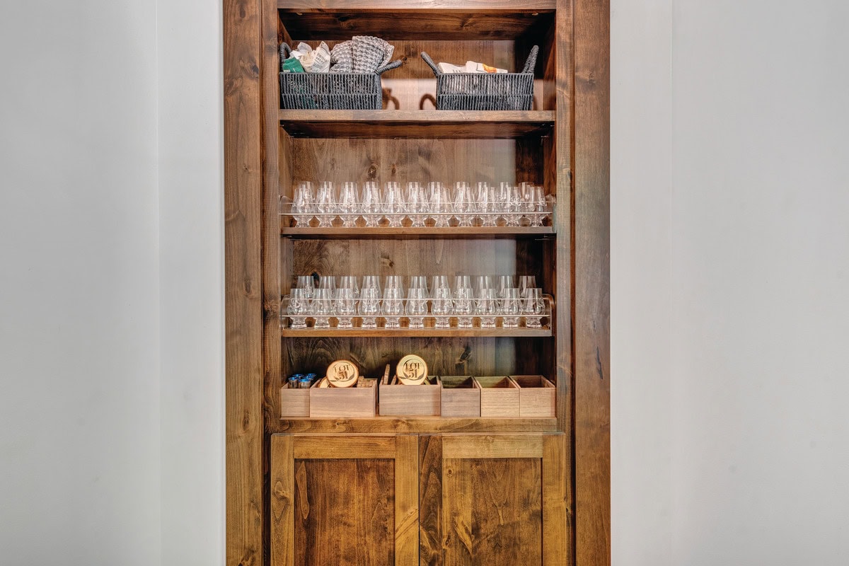 Custom shelves containing glassware conceal a secreat door leading to the downstairs speakeasy.
