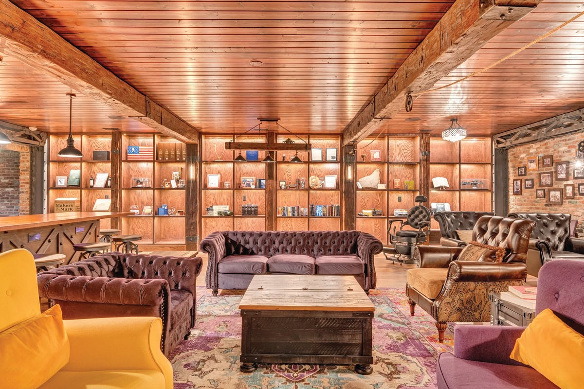 A wall with lighted shelves in the speakeasy displays some of Rob LaBella's favorite collectables, including a framed patent for "Gravity Distortion and Time Displacement"
