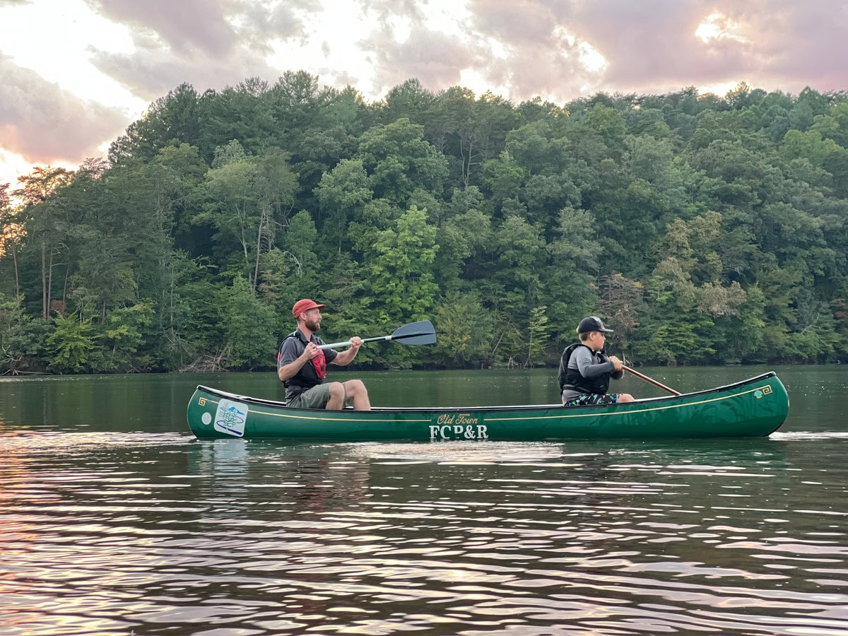 Two men in green canoe on Smith Mountain Lake.