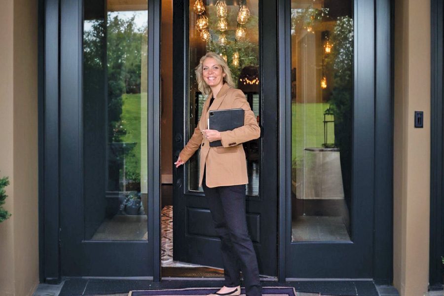 Jada Turner standing at the entrance of a luxury waterfront home at Smith Mountain Lake